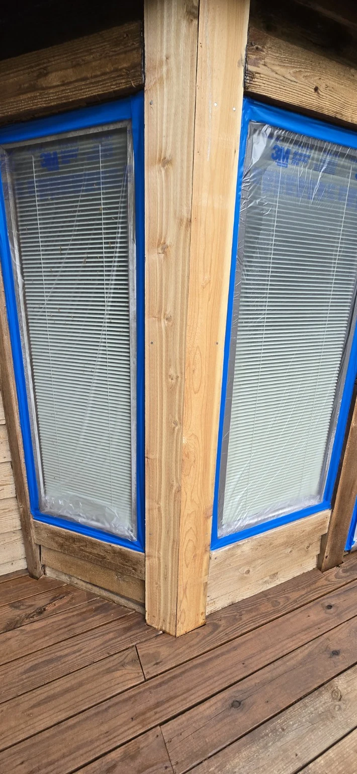 New cedar trim fitted around bay windows during siding restoration