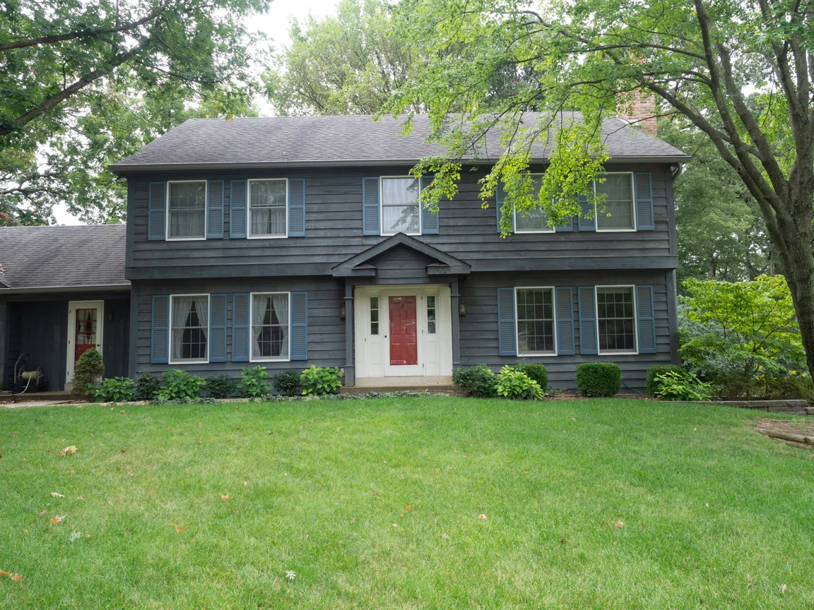 Cedar-sided home before renewal of its existing solid-color finish