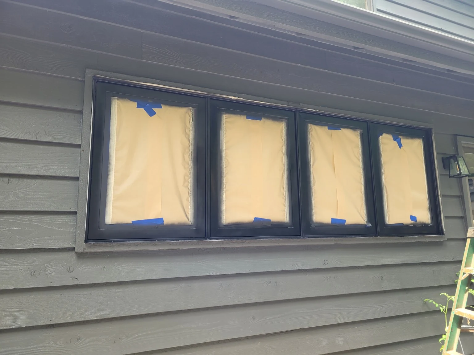 Window glass carefully masked before spray refinishing aluminum frames